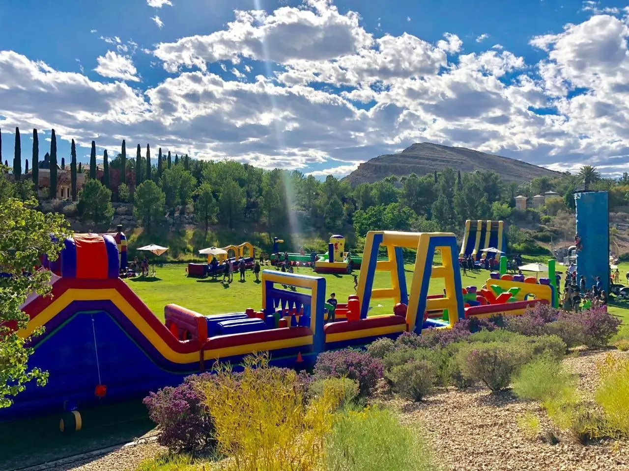 Large outdoor event multiple inflatable obstacle courses slides children playing for rent in Las Vegas