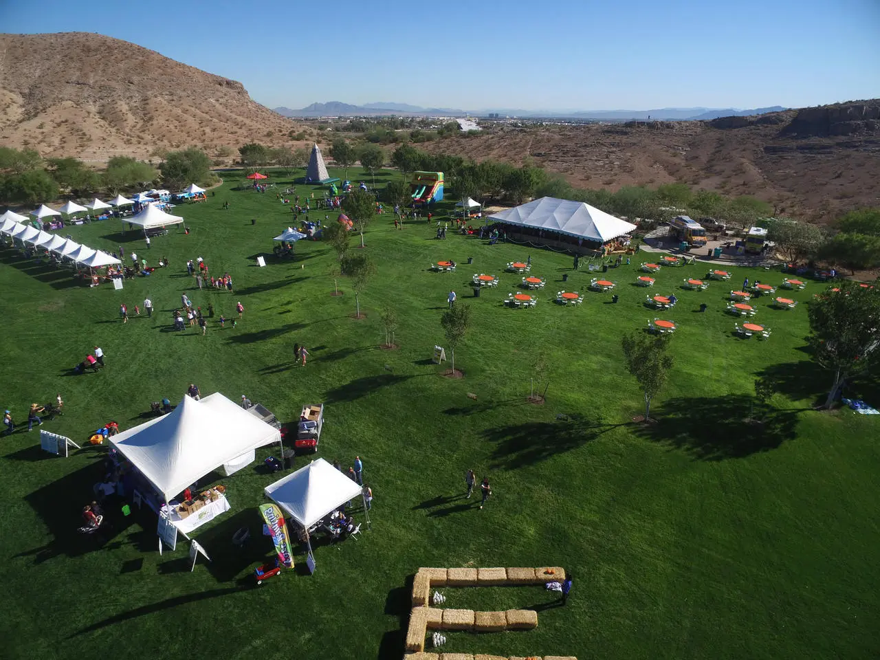Aerial view outdoor company picnic orange tables inflatables tents for rent in Las Vegas