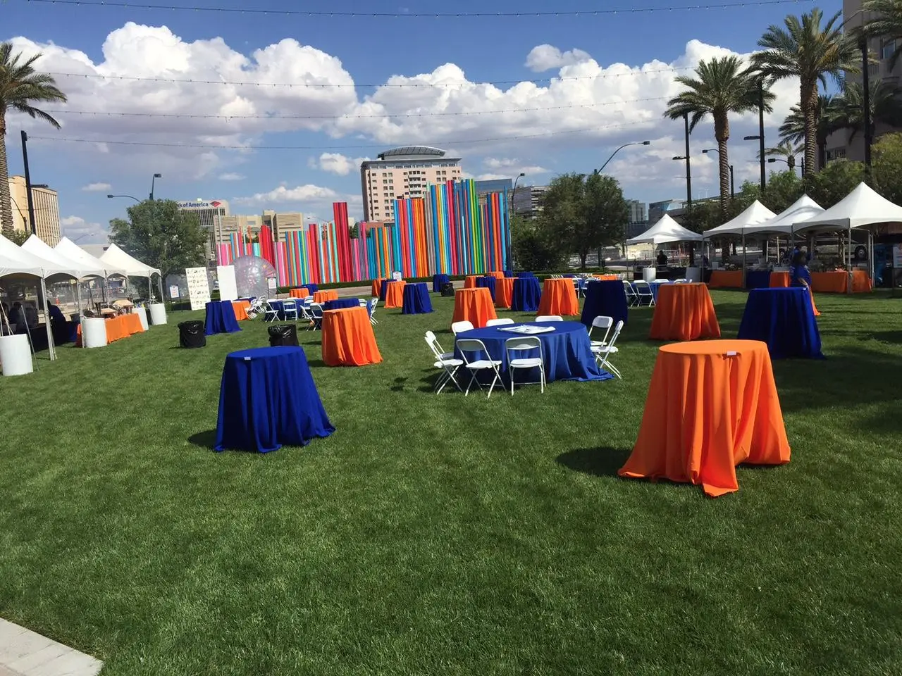 Company picnic with blue and orange tables and tents