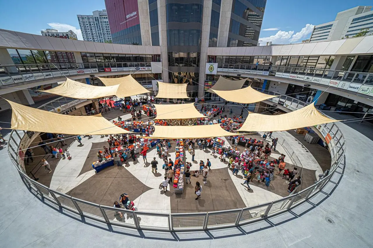 Aerial view of an outdoor market with vendor stalls and shade sails