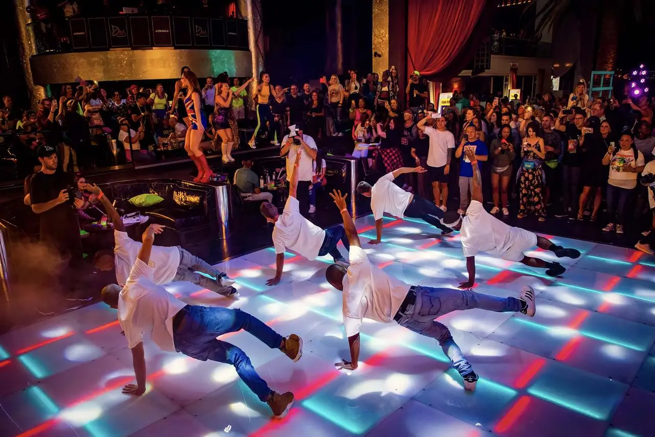 Breakdancers performing on an illuminated dance floor
