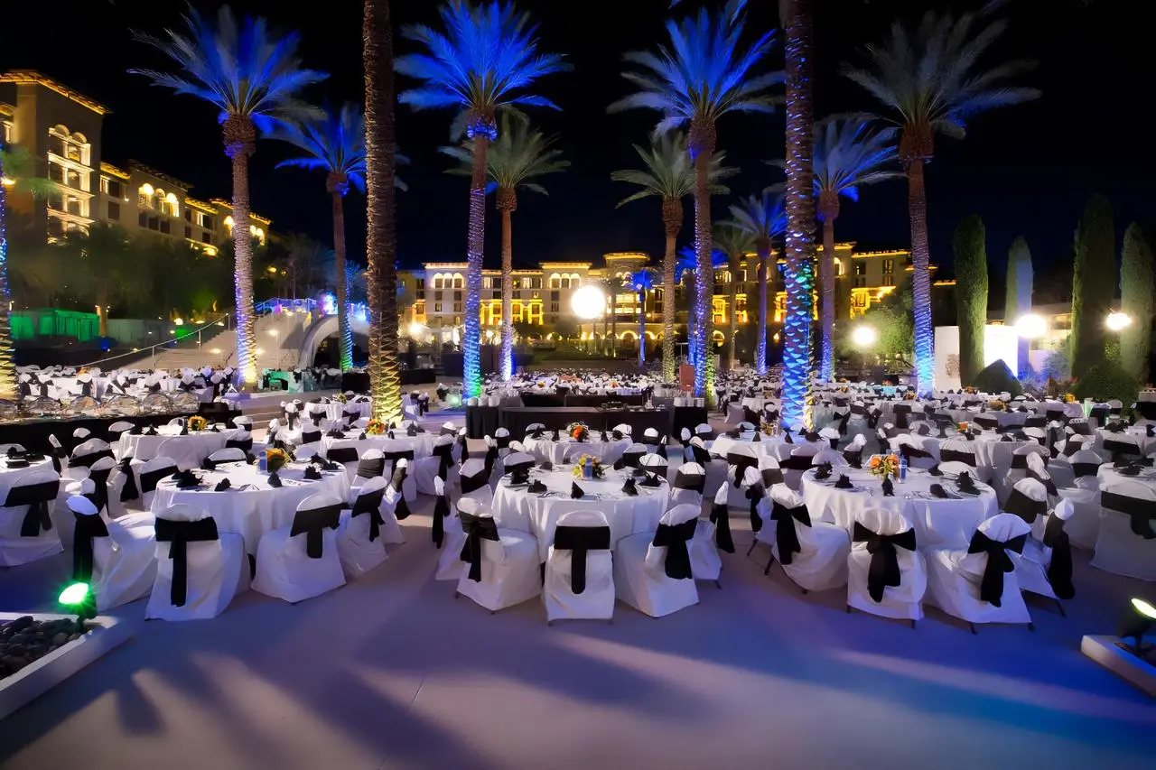 Outdoor gala blue lit palm trees white tables black sashes for rent in Las Vegas
