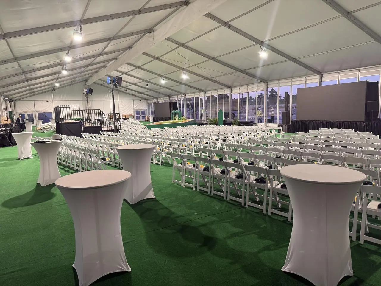 White event tent conference chairs stage screens construction site background for rent in Las Vegas