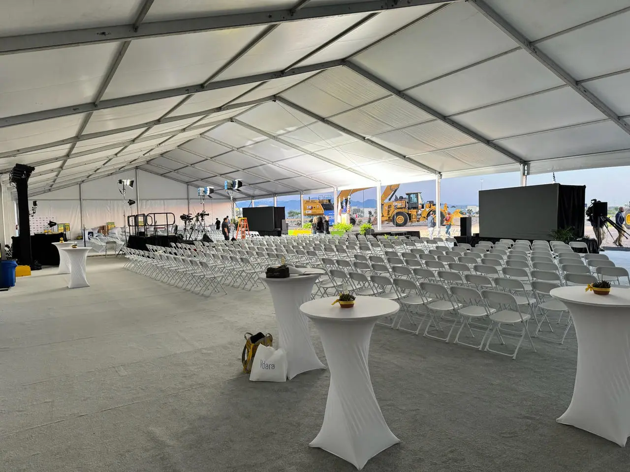 White event tent interior stage chairs construction vehicles background for rent in Las Vegas