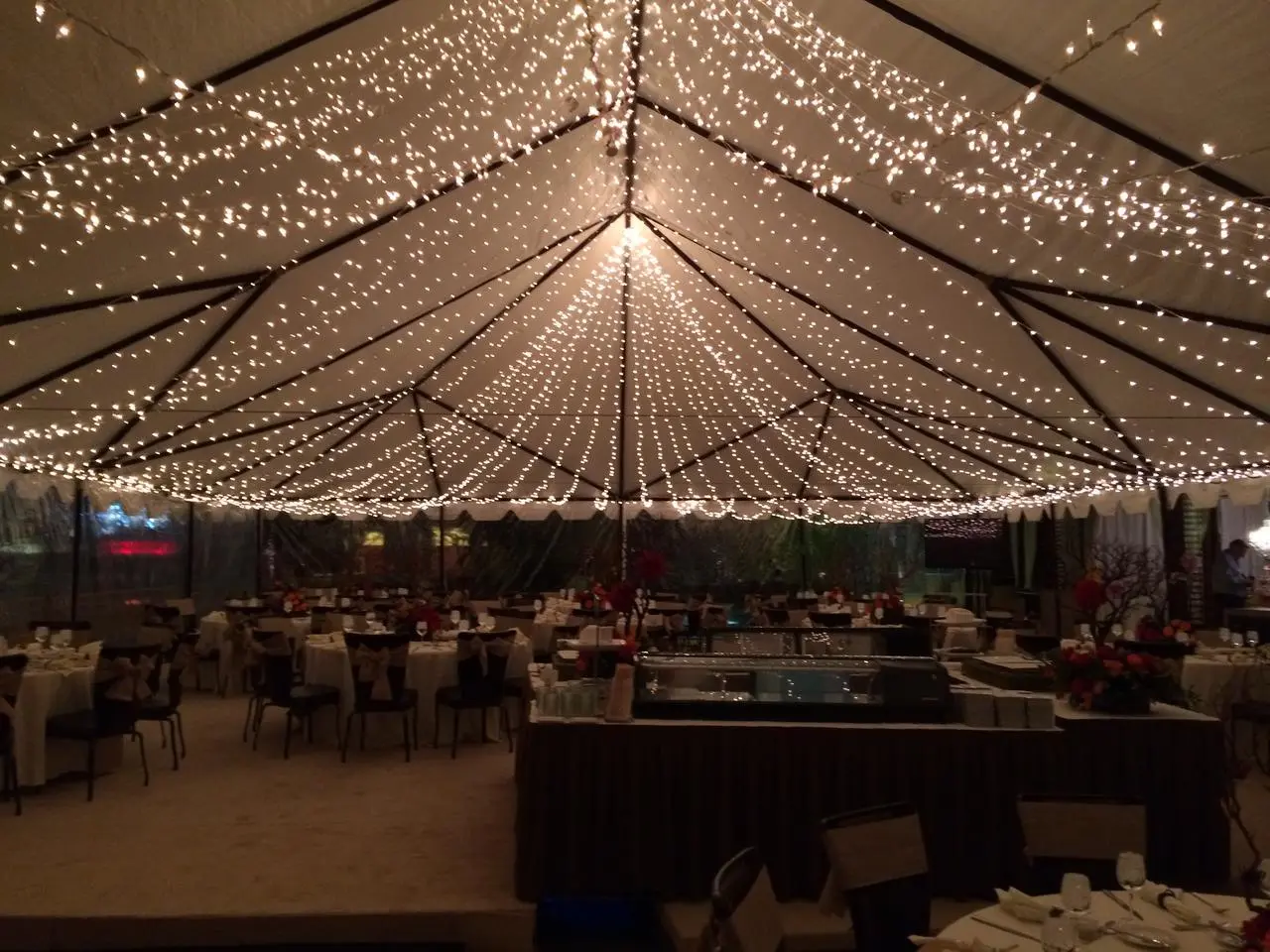 White event tent string lights round tables buffet station evening event for rent in Las Vegas